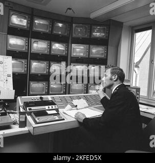 La sécurité du métro en 1970s. Le flux des caméras de surveillance du métro est surveillé. Un homme dans la salle de contrôle a de nombreux moniteurs différents devant lui et son travail est d'alerter la sécurité, la police ou l'ambulance s'il voit quelque chose se produire. Suède 1970s. Kristoffersson Banque D'Images