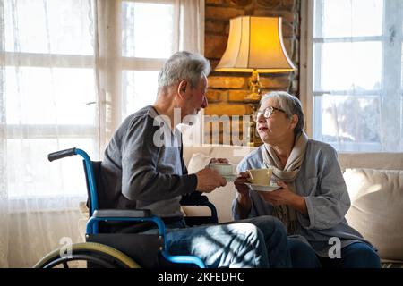 Homme mature avec un handicap en fauteuil roulant s'amusant avec sa femme. Concept d'amour de couple senior familial Banque D'Images