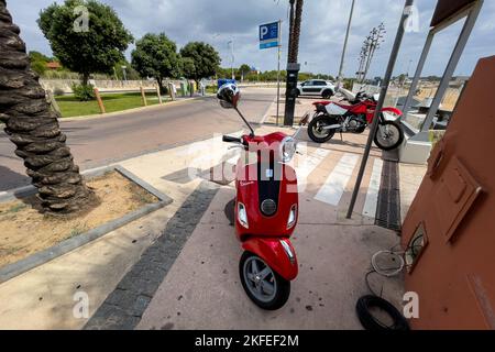 Le scooter Vespa rouge est stationné dans la rue Banque D'Images