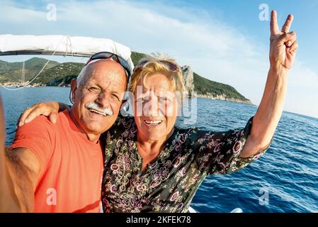 Couple expérimenté aventureux prenant le selfie à l'île de Giglio sur un hors-bord de luxe - concept de mode de vie de voyage de personnes âgées actives sur le bon moment de visite - retraité Banque D'Images