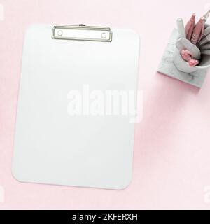 Bureau plat féminin de la scène de bureau de bureau avec des articles de papeterie blanc et argent, y compris une maquette d'un bloc-notes blanc vierge o Banque D'Images