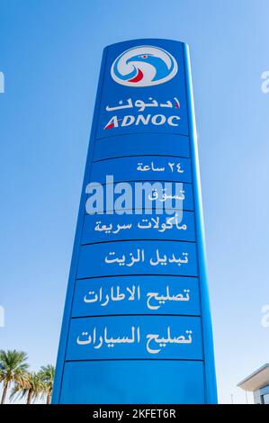 Station-service ADNOC signe bleu écrit en arabe contre le ciel bleu, une station-service au Moyen-Orient Banque D'Images