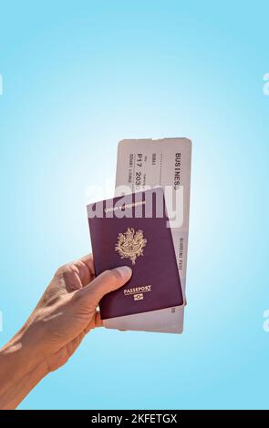 Passeport européen et billet d'avion d'affaires pour aller à Dubaï avec fond bleu maintenu par une femme, destination de voyage Banque D'Images