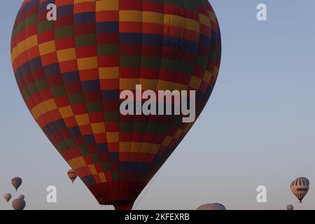 Grand ballon d'air chaud multicolore volant contre le ciel bleu Banque D'Images