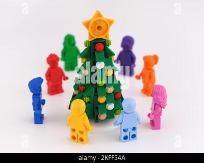 Tambov, Fédération de Russie -15 novembre 2022 Minifigures monochromes Lego debout dans un cercle autour d'un arbre de Noël. Arrière-plan blanc Banque D'Images