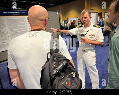 KISSIMMEE, Floride (sept 14, 2022) Lt. Cmdr. Erik Anderson, de l'unité de recherche médicale navale (ANORM)-Dayton, présente une affiche de recherche au Symposium de recherche sur le système de santé militaire (MHSRS). Le NAMRU-Dayton, qui fait partie de l’entreprise de recherche et développement médicaux de la Marine, a assisté au MHSRS, la première réunion scientifique du ministère de la Défense qui se concentre spécifiquement sur les besoins médicaux uniques du Warfighter. Ce symposium éducatif annuel réunit des professionnels de la santé, des chercheurs et des leaders du Département du développement pour quatre jours d'apprentissage critique, de partage intensif d'idées et de développement de relations. Banque D'Images