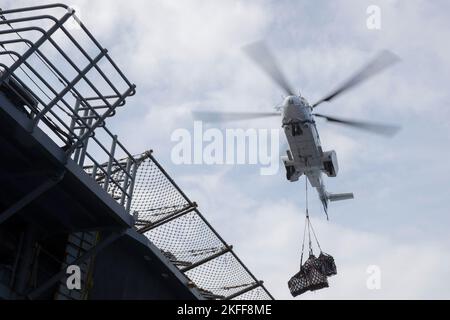 220915-N-XN177-2159 MER DES PHILIPPINES (SEPT 15, 2022) – un hélicoptère AS-332 Super Puma livre une charge de fournitures au transporteur d'assaut amphibie USS Tripoli (LHA 7) au cours d'un réapprovisionnement en mer avec le navire de fret et de munitions du Commandement du Sealift militaire USNS Carl Brashear (T-AKE 7) le 15 septembre 2022. Tripoli opère dans la zone d'opérations de la flotte américaine 7th afin d'améliorer l'interopérabilité avec ses alliés et ses partenaires et de servir de force de réaction prête à l'emploi pour défendre la paix et maintenir la stabilité dans la région Indo-Pacifique. Banque D'Images