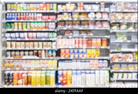 Des rangées de paquets avec des aliments et des boissons sur les étagères d'une épicerie en Asie, image floue défocased comme toile de fond ou d'arrière-plan d'affaires Banque D'Images