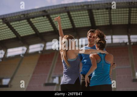 Un coéquipier joyeux félicite ses amies féminines pour leur réussite au marathon Banque D'Images