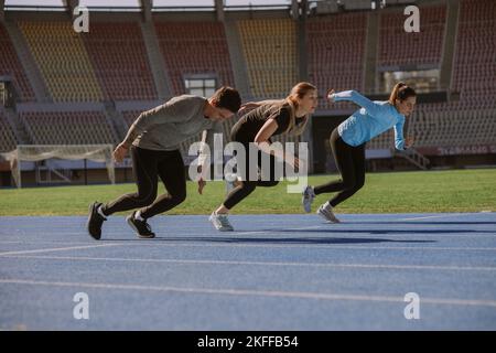 Deux filles et un garçon se sont défiés qui est le plus rapide. Ils sont sprinting Banque D'Images