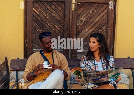 Deux touristes, un couple, prend une pause après avoir traîner toute la journée. Ils sont fatigués et ont une belle conversation Banque D'Images