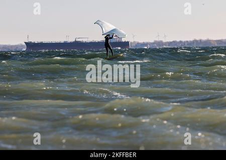 Kiel, Allemagne, 18 novembre 2022. Un surfeur de Wingfoil surfent sur la mer baltique par temps ensoleillé et orageux. Credit: Frank Molter/Alamy Live News Banque D'Images