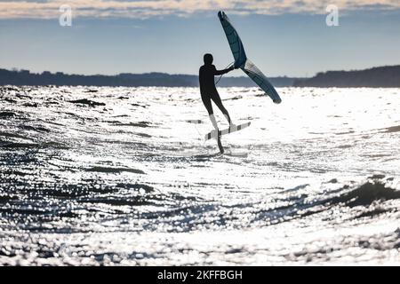 Kiel, Allemagne, 18 novembre 2022. Un surfeur de Wingfoil surfent sur la mer baltique par temps ensoleillé et orageux. Credit: Frank Molter/Alamy Live News Banque D'Images