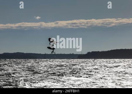 Kiel, Allemagne, 18 novembre 2022. Un surfeur de Wingfoil surfent sur la mer baltique par temps ensoleillé et orageux. Credit: Frank Molter/Alamy Live News Banque D'Images