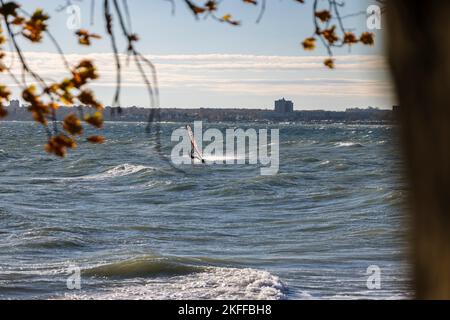 Kiel, Allemagne, 18 novembre 2022. Une planche à voile surfent sur la mer baltique par temps orageux et ensoleillé. Credit: Frank Molter/Alamy Live News Banque D'Images