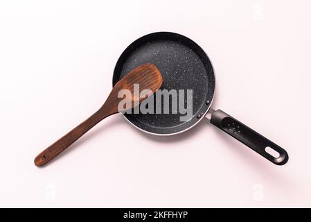 poêle à repasser avec spatule en bois, vue de dessus isolée sur fond blanc Banque D'Images