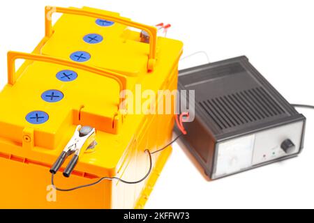 batterie de voiture jaune avec chargeur de batterie de voiture isolé sur fond blanc. Banque D'Images