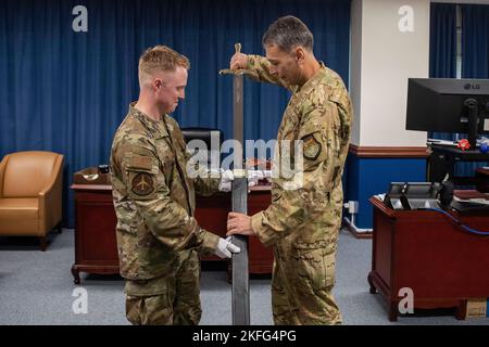 Le colonel Andrew Roddan, commandant de l’escadre du 374th Airlift, présente l’épée de cérémonie de l’escadre nouvellement présentée avec le sergent d’état-major. Michael Smith, 374th escadron de maintenance artisan de la technologie des métaux, à la base aérienne de Yokota, Japon, le 15 septembre 2022. L'épée a été présentée au commandant en vue de son dévoilement au ballon de l'Armée de l'Air de Yokota en 2022. Banque D'Images