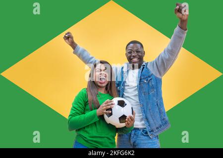 Couple de fans brésiliens heureux de célébrer le football ou le match de football sur fond jaune et vert Banque D'Images