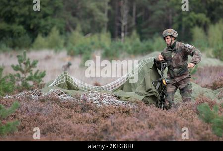 Un parachutiste français rassemble son parachute assigné lors de l'exercice Falcon Leap à la zone de chute Heide de Hechtselse, Hechtel-Eksel, Belgique., 15 septembre 2022. Plus de 1000 parachutistes du monde entier, 13 nationalités différentes, plusieurs aéroglisseurs par jour, et entraînement avec d'autres équipements pendant deux semaines. Il s'agit du plus grand exercice technique aéroporté de l'OTAN. Banque D'Images