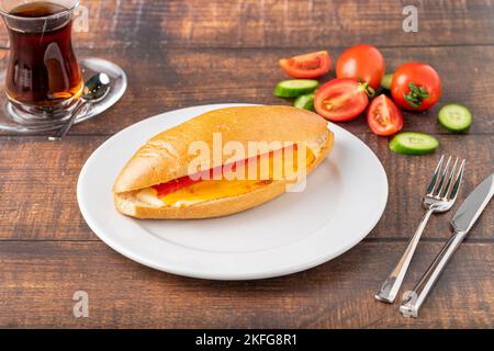 sandwich à trois fromages avec tomate et concombre sur une table en pierre sombre Banque D'Images