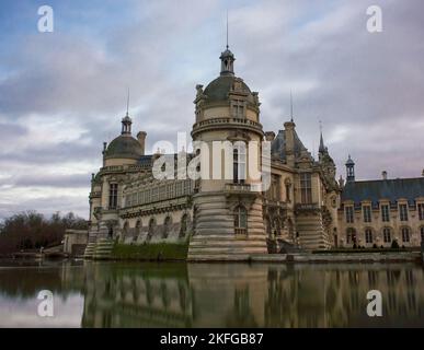 Domaine de Chantilly, château de Chantilly au coucher du soleil, reflet du ciel nuageux dans l'étang. Célèbre destination touristique près de Paris. Banque D'Images