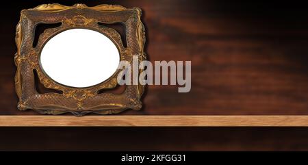 Gros plan d'un cadre photo ancien vide (couleur or et bronze) sur une étagère en bois avec espace de copie. Photographie. Banque D'Images