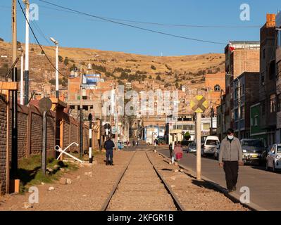 Puno, Pérou - 28 juillet 2022: Les voies ferrées passent par le milieu de la ville et que les piétons marchent comme s'il s'agissait d'un trottoir Banque D'Images