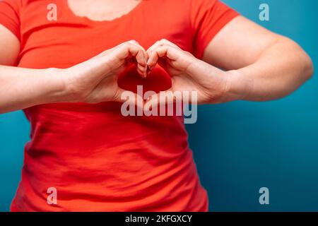 Femme faisant des mains en forme de coeur, assurance maladie de coeur, responsabilité sociale, gratitude, don, bonne œuvre bénévole, journée mondiale du cœur Banque D'Images