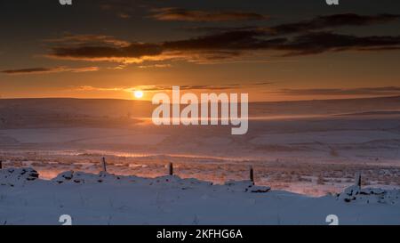 Le soleil de Misty Moody se lève au-dessus de la lande de Rossendale Wintry. Des landes sombres couvertes de neige avec un ciel spectaculaire et coloré. Banque D'Images