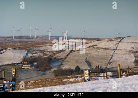 Éoliennes sur les collines lointaines. Campagne vallonnée avec de la neige au sol. Ciel bleu froid Banque D'Images