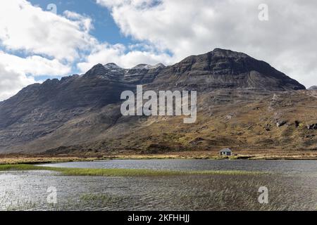 La montagne de Liathach s'enveloppait dans le nuage tandis que la douche à neige sautait à travers ses flancs, vue à travers Lochan an Lasgair, Torridon, Écosse, Royaume-Uni Banque D'Images