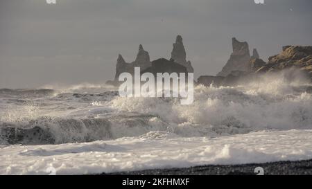 Piles de la mer Baltique à Vik, Islande. Brisant les vagues de la mer sur la plage de sable noir avec des jets de mer sur les vagues Banque D'Images