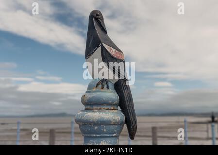 Sculpture de magpie en métal sur le dessus du poteau en métal sur l'ancienne jetée en pierre de Morecambe, Lancashire Banque D'Images