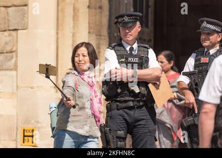 Touriste prenant un selfie au château de Windsor avec les policiers qui gardaient l'entrée. Windsor Castle Londres UK la veille du mariage du Prince Harrys Banque D'Images