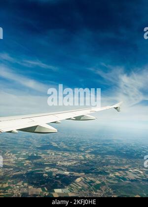 Image rognée d'un avion volant contre un ciel bleu au-dessus d'une vue panoramique sur le paysage le jour ensoleillé Banque D'Images