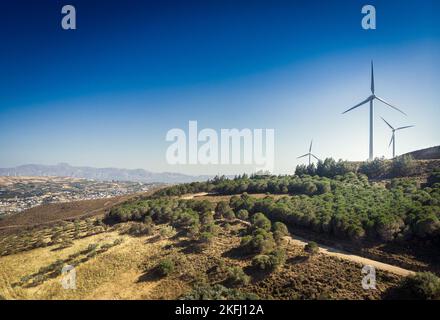 Vue panoramique sur la montagne avec des éoliennes et des plantes luxuriantes qui poussent sur des paysages vallonnés avec un ciel bleu clair Banque D'Images