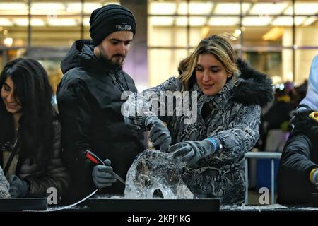 Londres, Royaume-Uni. 18th novembre 2022. Deux participants participent à une séance de sculpture sur glace à l'ours polaire au Festival de glace d'hiver. Il se déroule sur trois jours à travers le domaine de Canary Wharf - du jeudi 17th au soir du samedi 19th, où les visiteurs peuvent observer de grandes sculptures de glace en cours de création, flâner le long de la piste de 15 espèces d'animaux sauvages en voie de disparition et prendre part à des activités pratiques, sculpter leur propre ours polaire ou sculpter sur un mur de grafitti glacé. Crédit : onzième heure Photographie/Alamy Live News Banque D'Images