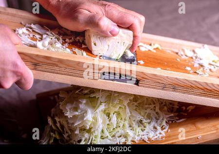 Préparer le chou pour la fermentation. Coupe du chou sur le couteau. Choucroute maison. Banque D'Images