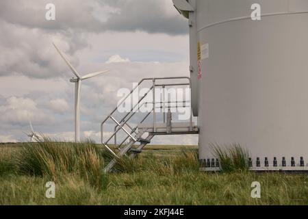Base d'une éolienne avec une autre éolienne dans le sol arrière. Au-dessus des landes avec ciel nuageux. Banque D'Images