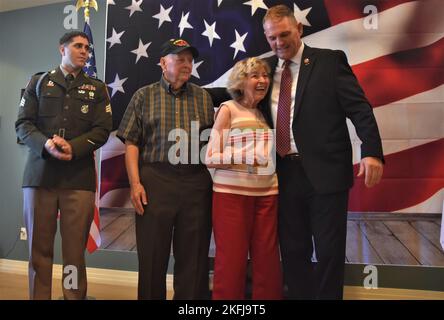 Sergent d'ancien combattant de la guerre de Corée. Norman Deck (deuxième à droite) regarde sa femme de 69 ans Shirley reçoit un câlin de Rick Kreiberg (à droite), fondateur et directeur exécutif, Veterans Affinity, comme Sgt. Paul Barnett (à gauche), recruteur, poste de recrutement Gilbert, compagnie de recrutement Tempe surveille également, lors d’une cérémonie spéciale reconnaissant le service de guerre de la Corée de Deck, le 19 septembre, l’installation de vie assistée de la Maison Savanna, Gilbert, Arizona. La cérémonie a eu lieu exactement 67 ans depuis que Deck a quitté l’Armée le 19 septembre 1955. Banque D'Images