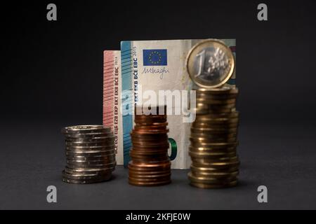 Billets en euros sur fond sombre. Concept de billets de vingt euros avec des pièces en euros empilées devant et hors foyer. Copier l'espace. Banque D'Images