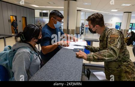 Les passagers du premier vol du Patriot Express passent par un Airman du 727th Air Mobility Squadron au terminal de passagers de la Royal Air Force Mildenhall sur la RAF Mildenhall, en Angleterre, le 20 septembre 2022. Le vol Patriot Express, également connu sous le nom de rotateur, est un vol charter commercial du ministère de la Défense qui fournit un soutien international aux militaires et civils des États-Unis et à leurs familles qui changent de poste de façon permanente vers le Royaume-Uni. Banque D'Images