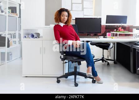 Shes a obtenu le succès créatif écrit partout. Portrait d'un jeune designer assis à son poste de travail dans un bureau. Banque D'Images