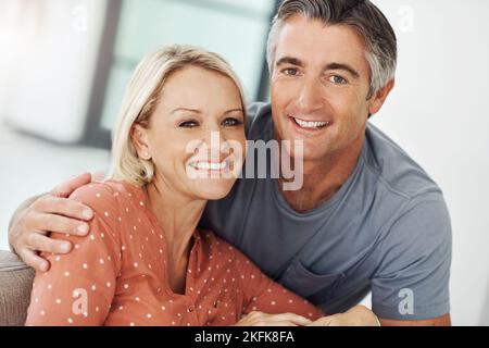 Bien être ensemble pour toujours. Portrait court d'un couple affectueux et mature qui se détend sur le canapé à la maison. Banque D'Images