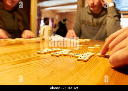 Amis jouant au jeu de Scrabble en étant assis Banque D'Images