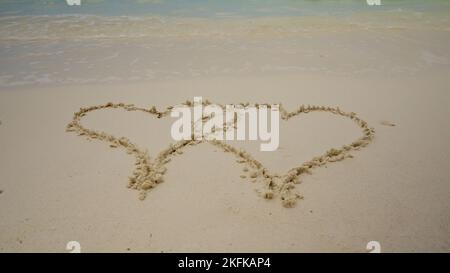 Forme de coeur dessiné dans le sable sur la plage Banque D'Images