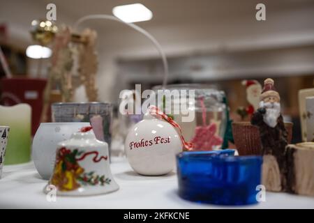 PRODUCTION - 17 novembre 2022, Thuringe, Leinefeld-Worbis : une boule de Noël avec l'inscription « Joyeux Noël » se trouve sur une table du magasin social Caritas « inpetto ». Outre les vêtements pour femmes, hommes et enfants, le complexe géré par le diocèse d'Erfurt propose des meubles de toutes sortes, des textiles ménagers, des photos et d'autres articles décoratifs. Les experts disent que la volonté de faire un don aux magasins de vêtements de Thuringe est bonne. Mais ils ont d'autres problèmes cet hiver. (À dpa 'les placards de vêtements en Thuringe attendent courir en hiver') photo: Swen Pförtner/dpa Banque D'Images