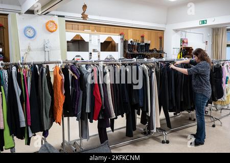 PRODUCTION - 17 novembre 2022, Thuringe, Leinefeld-Worbis: Anja Göthling, une employée du magasin social Caritas "inpetto", se tient sur un rail de vêtements. Outre les vêtements pour femmes, hommes et enfants, le complexe géré par le diocèse d'Erfurt propose des meubles de toutes sortes, des textiles ménagers, des photos et d'autres articles décoratifs. La volonté de faire un don aux magasins de vêtements de Thuringe est bonne, disent les experts. Mais ils ont d'autres problèmes cet hiver. (À dpa 'les placards de vêtements en Thuringe attendent courir en hiver') photo: Swen Pförtner/dpa Banque D'Images