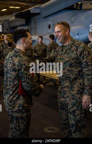 US Navy Hospital Corpsman 3rd classe Jonathon Kazarian, un corpsman de peloton affecté à la compagnie de golf, Bataillon Landing Team 2/5, 31st Marine Expeditionary Unit, à gauche, reçoit un certificat et une pièce de monnaie du U.S. Marine corps Col. Matthew C. Danner, Le commandant du MEU 31st après un tournoi de combat au sol du Marine corps Martial Arts Program à bord du navire d'assaut amphibie USS Tripoli (LHA-7), dans la mer des Philippines, le 23 septembre 2022. Le tournoi a eu lieu pour tester les compétences des Marines et des marins et pour construire la camaraderie par la compétition. Le MEU 31st fonctionne à bord de l' Banque D'Images